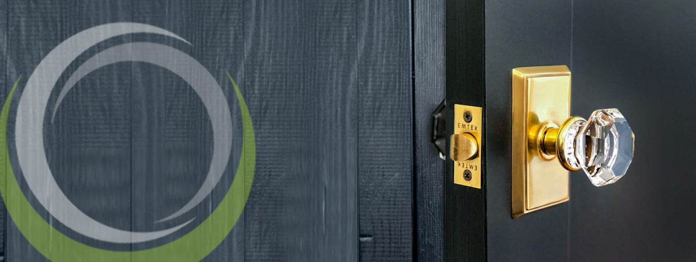 Gold door hardware with crystal knob on dark wood door.